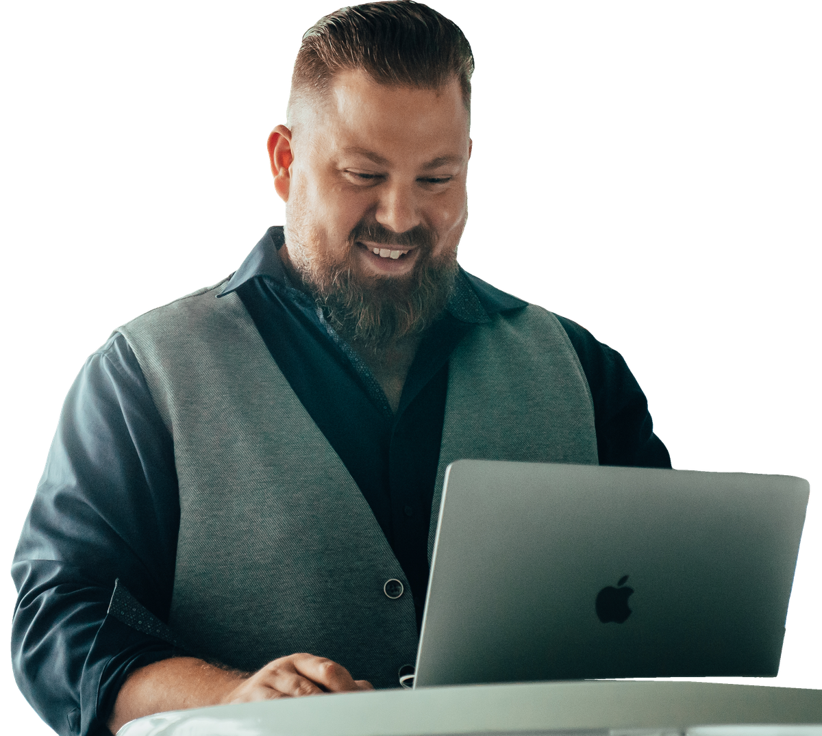Benjamin Kötting lächelt bei der Arbeit am MacBook.