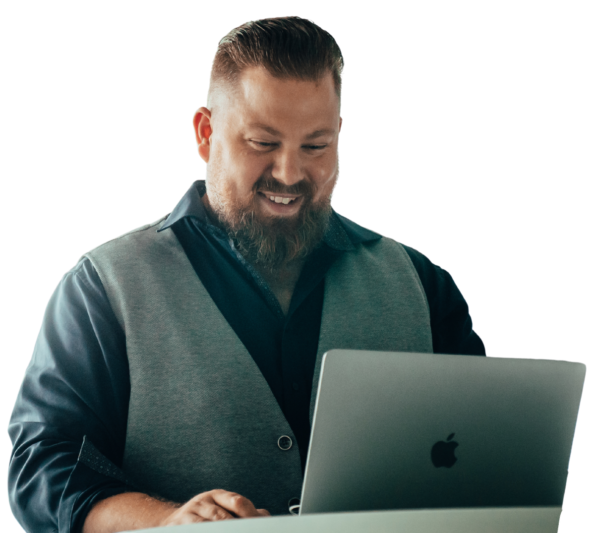 Benjamin Kötting lächelt bei der Arbeit am MacBook.